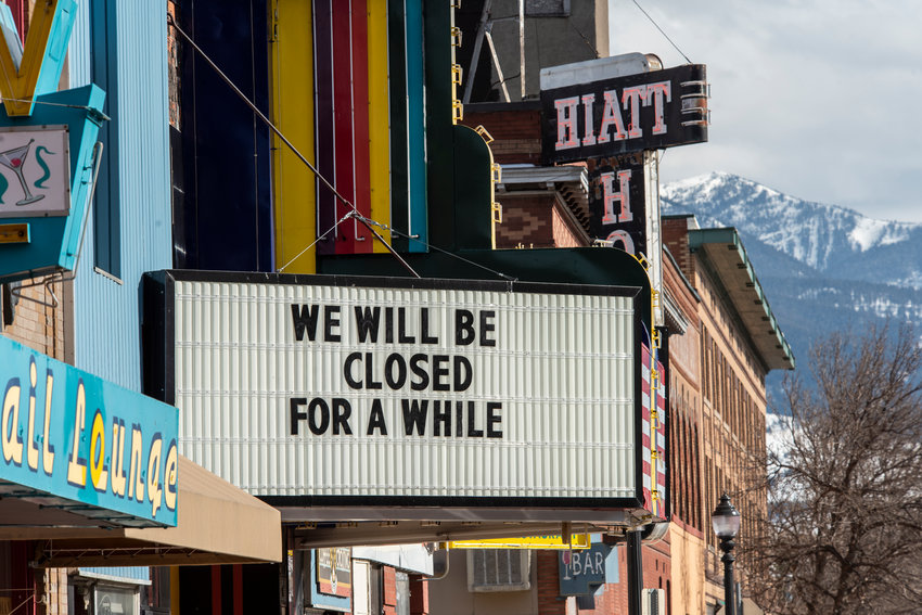 A movie theater displays a sign stating 'we will be closed for a while.'