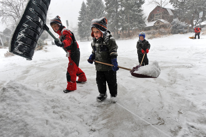 Young children shovel snow