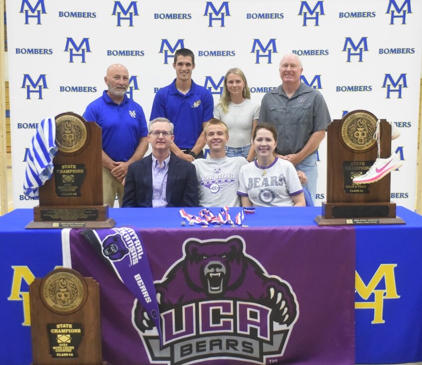 Mountain Home's William Hill (front, middle), pictured with family and coaches, signed Monday a National Letter of Intent to run both track and cross country at the University of Central Arkansas.