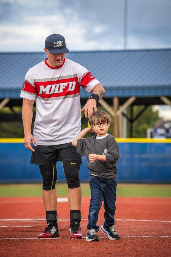 Tommy Feliccia of Mountain Home Fire Department assists the department's  Fire Buddy, Carson Placker, in throwing out the first pitch at the third annual Mountain Home Fire Department-Police Department Charity Ragball Game Saturday.


Bobby Scott Photography photo