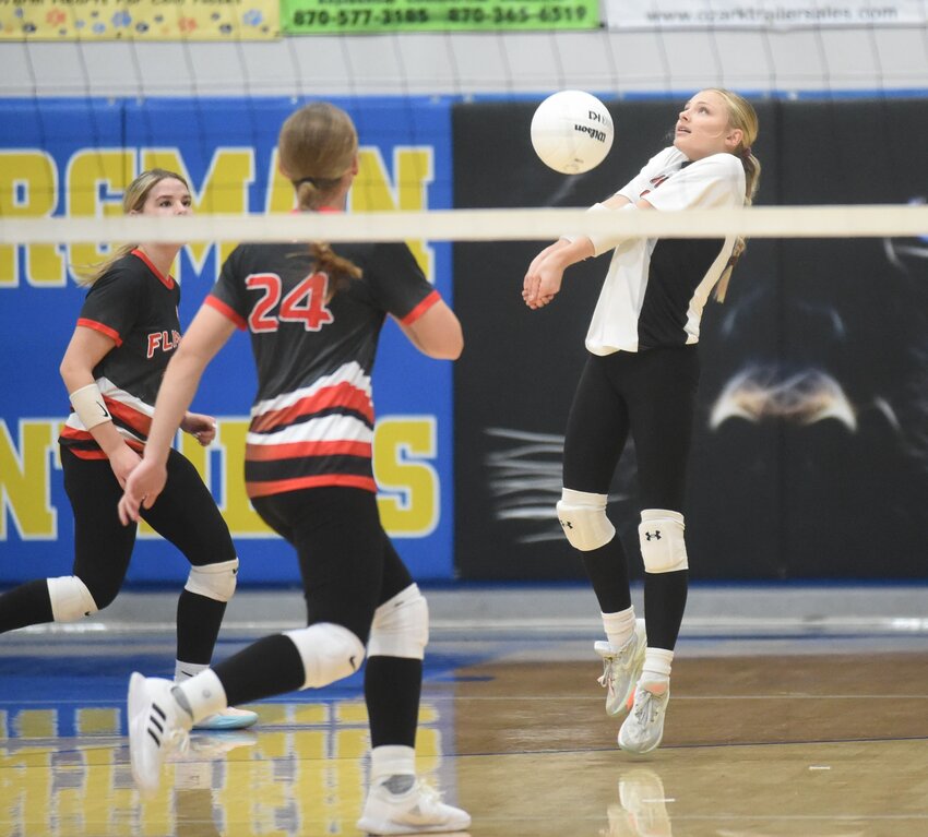 Flippin's Jenna Bradley (right) makes a pass as teammates Abbi Davis and Adrianne Benedict converge on the play Monday against Yellville-Summit.