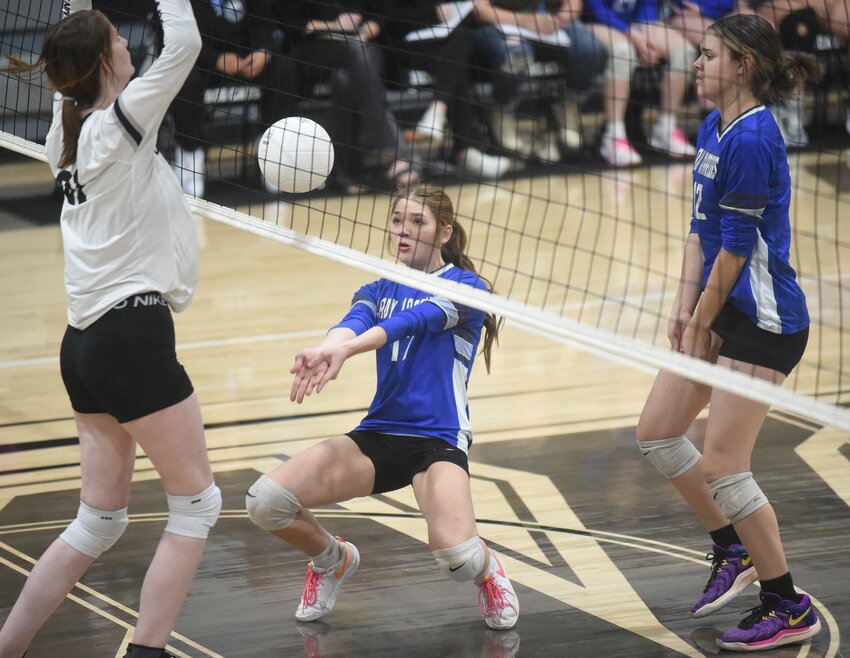 Cotter's Zaylor Brotherton attempts to play a ball off the net during the Lady Warriors' three-set victory over Izard County on Tuesday.