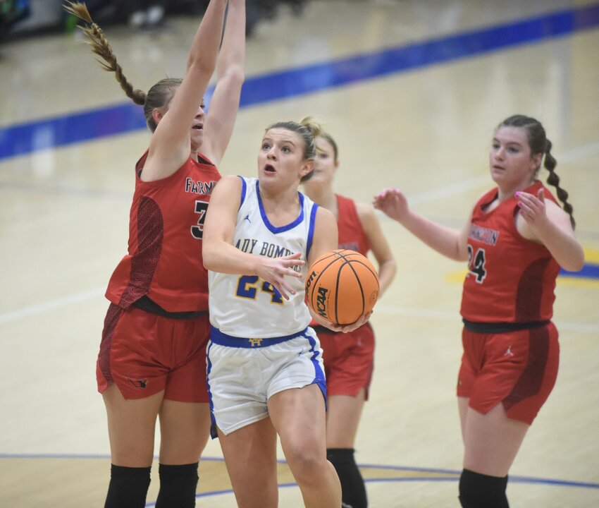 Mountain Home's Laykin Moore scoops a layup under Farmington's Kaycee McCumber on Tuesday night at The Hangar.