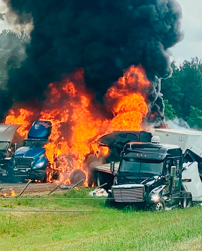 Flames and smoke billow from trucks involved in a deadly multiple-vehicle crash along Interstate 30 Wednesday in southwestern Arkansas.   Joni Deardorff/AP Photo