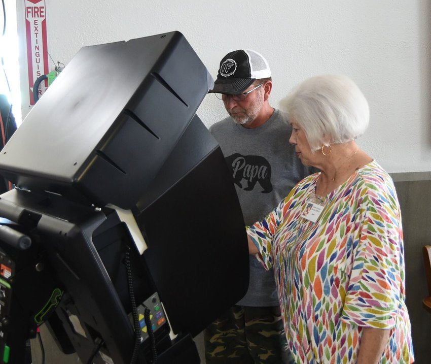 Poll worker Carol Hildebrand (foreground) walks Chad Hershberger through using the voting machine Monday at the Baxter County Courthouse.   Scott Liles/The Baxter Bulletin