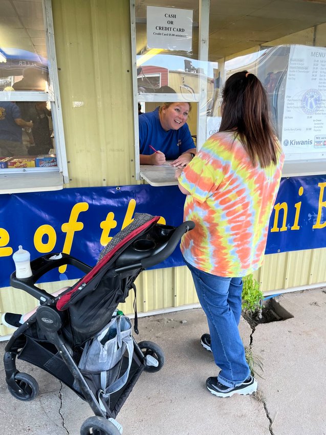Kiwanis Club of Mountain Home Treasurer Allison Parks takes an order Wednesday evening at the 2022 Baxter County Fair. The club has planned for a busy fair season, ordering 1,200 burgers for its yearly food booth.   Helen Mansfield/The Baxter Bulletin
