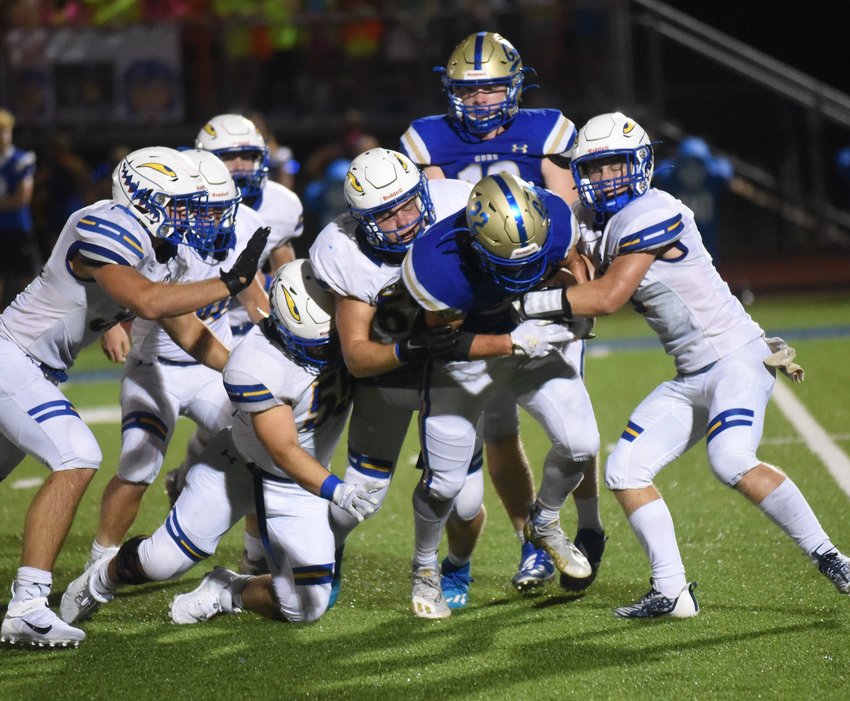 A group of Bombers brings down Harrison's Braden Long during Mountain Home's 20-7 loss Friday night.