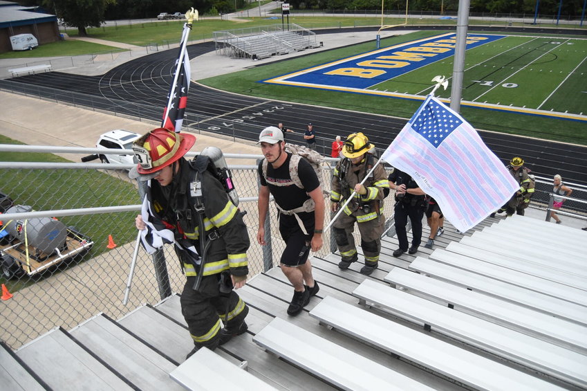 Participants in the 9/11 Memorial Stair Climb reach the top of the Bomber Stadium bleachers for the first time Sunday morning. Participants climbed the bleachers 55 times to replicate the 110-story climb faced by New York firefighters at the World Trade Center on 9/11.   Scott Liles/The Baxter Bulletin