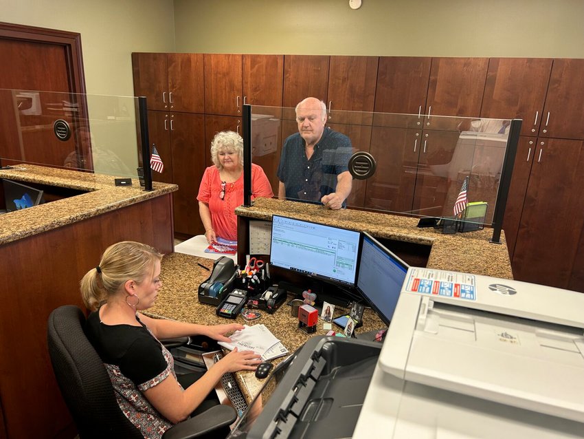 Baxter County Deputy Collector Kim Williams (seated) prepares a printed receipt for Debra and David Dail after they paid their property taxes Tuesday afternoon. The deadline to pay your 2021 property taxes is Monday.   Scott Lile/The Baxter Bulletin