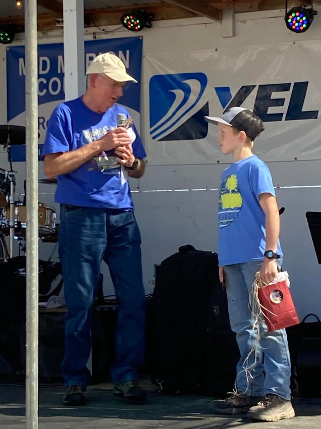 Turkey Trot attendee Logan Layton (right) caught the first plush turkey released Friday afternoon at the 76th annual Turkey Trot festival in Yellville. Logan exchanged the turkey for a gift bag that included a certificate for a frozen turkey and a gift card for an area barbecue restaurant.   Photo courtesy of the Mid-Marion County Rotary Club