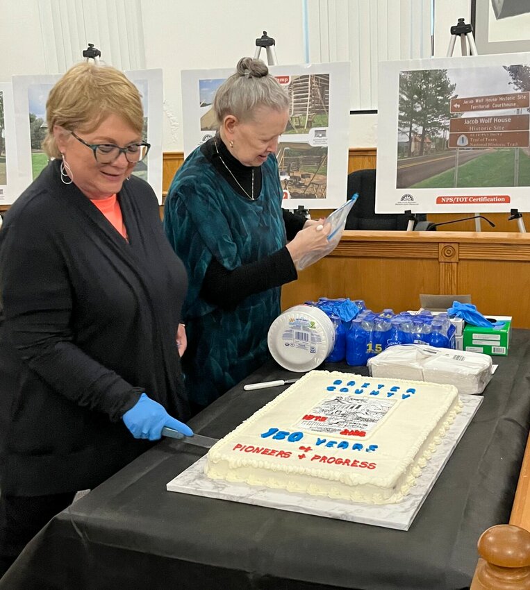 Volunteers cut the commemorative cake made by Shirley Pointer as part of Friday&rsquo;s ceremony at the Baxter County Courthouse, marking the county&rsquo;s Sesquicentennial on March 24.   Helen Mansfield/The Baxter Bulletin
