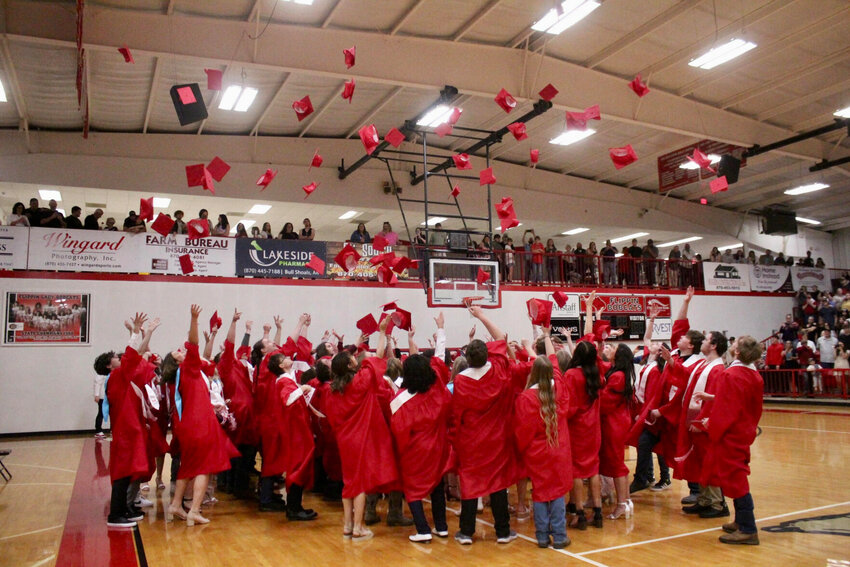 Flippin High School graduates throw their caps in the air Friday night after concluding commencement exercises at the Flippin High School gymnasium.   Ethan Granniss/Special to The Bulletin