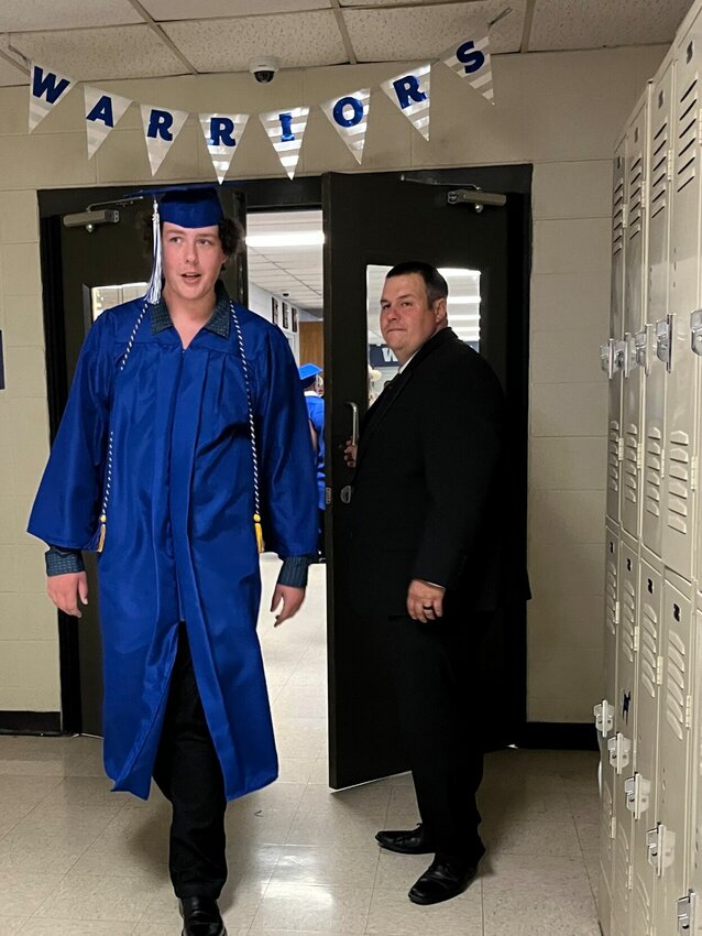 Cotter High School Principal Clark Gustin makes a final check on his 46 graduates before they prepare to line up for their big entrance Saturday night.   Helen Mansfield/The Baxter Bulletin