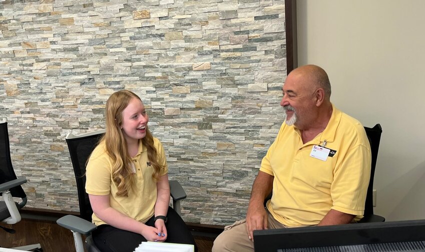 Lily Foster, a Mountain Home High School Class of 2023 graduate, visits with Baxter Health Auxiliary Volunteer Ed Lackland during their &ldquo;work&rdquo; shift at the information desk at the main entrance of the hospital. Foster began volunteering at Baxter Health as part of MHHS&rsquo; Service Learning Volunteer Internship Program, which allowed her to earn volunteer hours during the school day to include in her college application. She plans to study biology at the University of Central Arkansas in Conway in the fall.   Helen Mansfield/The Baxter Bulletin