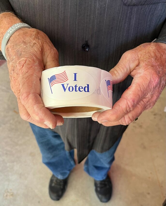A volunteer holds I voted stickers during the recent Mountain Home School Board election. A runoff for the school board seat is slated for Tuesday.   Helen Mansfield/The Baxter Bulletin