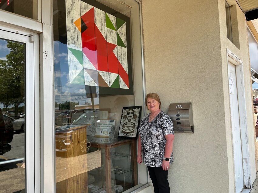 Baxter County Historical &amp;amp; Genealogical Society Vice-president and quilter Lisa Bullard Coleman poses next to a four-foot by four-foot quilt square she designed and painted as part of Baxter County&rsquo;s Sesquicentennial celebration this year. The cardinal, which hangs in the window of the Baxter County Heritage Center, is located at 808 S. Baker St. off The Square in Mountain Home.   Helen Mansfield/The Baxter Bulletin