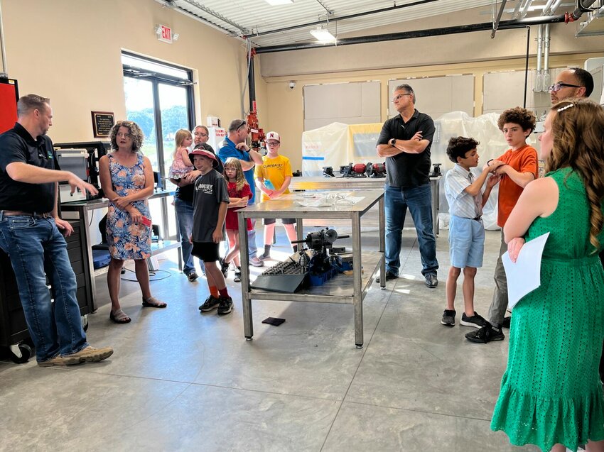 Nathan Lueck, director of Arkansas State University-Mountain Home&rsquo;s Secondary Center (far left) and ASUMH Workforce and Community Education Director Victor Beck (in the black shirt) give parents a tour of the university&rsquo;s Technical Center. Thursday night served as &ldquo;parents&rsquo; night&rdquo; during last week&rsquo;s Young Manufacturers Academy (YMA) camp at the center.   Helen Mansfield/The Baxter Bulletin
