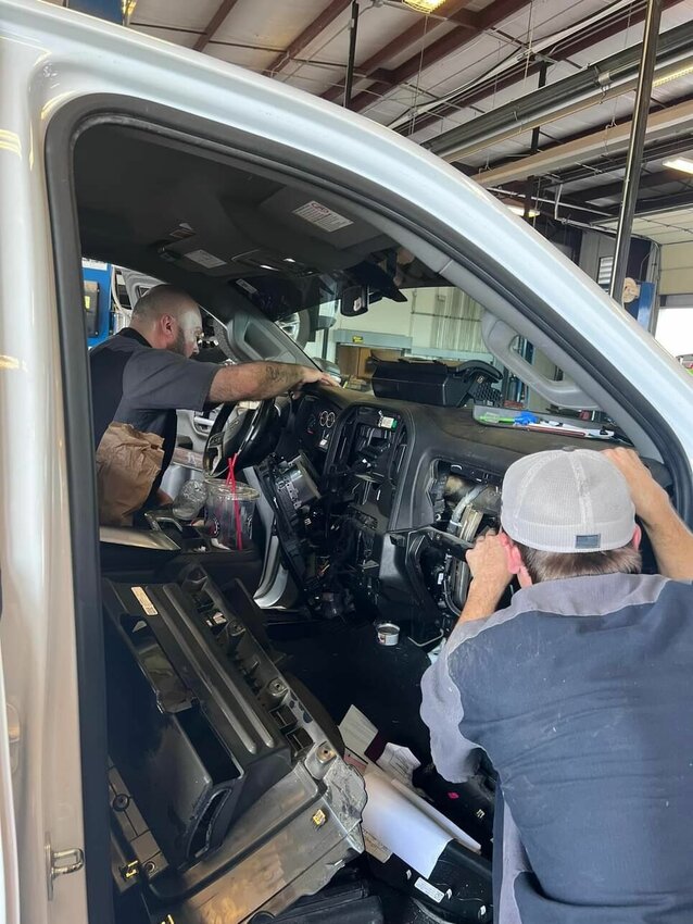Four technicians from Ultimate GMC spent roughly 90 minutes last Thursday taking the dashboard from a 2022 Chevrolet Silverado 2500 apart in order to find a stray kitten that had crawled in a hole located under the truck&rsquo;s gas pedal. Master Auto Tech Bryan Davis (left) ended up adopting the kitten for his 13-year-old daughter Liberty.   Submitted Photo