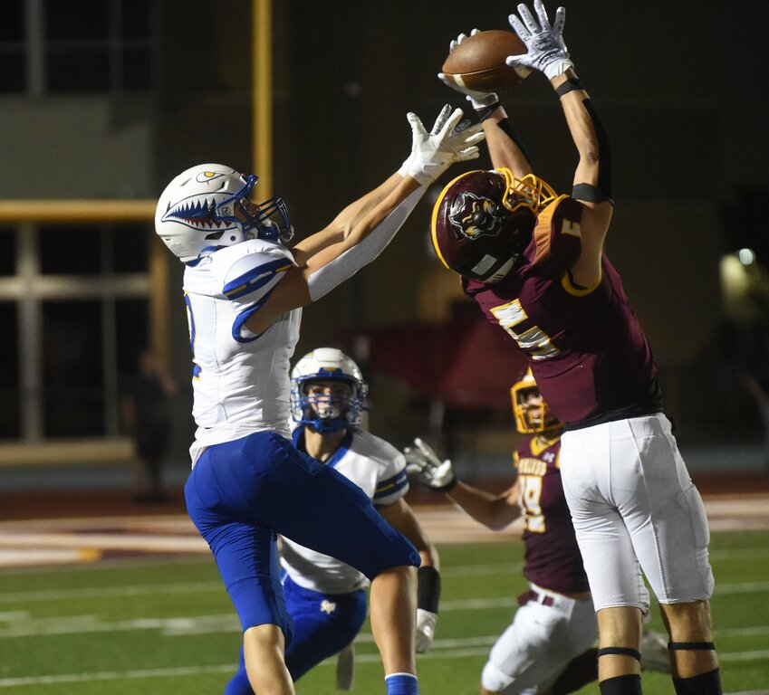 Lake Hamilton's Caleb Rouse (5) swipes an interception from Mountain Home receiver Carter Adkins on Friday night.