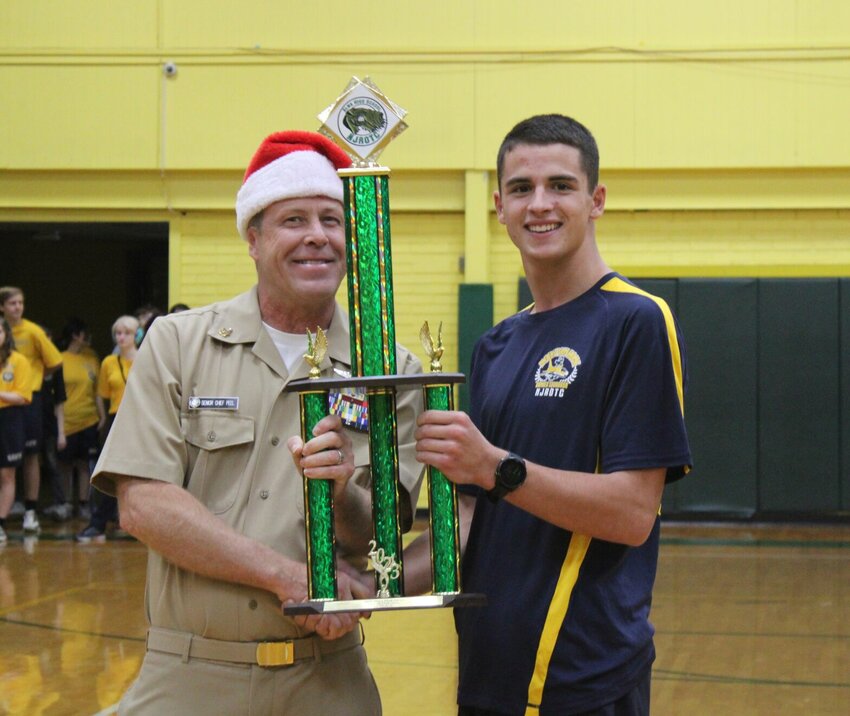 Senior Chief Troy Peel (left),&nbsp;Alma High School Naval Science instructor and former Mountain Home High School Naval Science instructor, presents Cadet Lt. Cmdr. Ryan Amick with the first-place overall trophy at the annual Airedale Invitational.   Photo Submitted