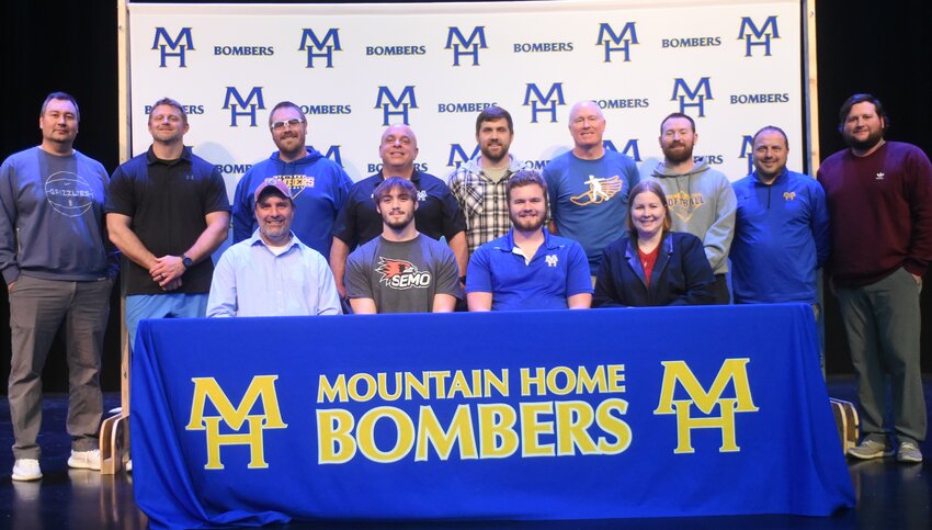Mountain Home's Robert Dover signed Wednesday to play college football at Southeast Missouri State University. Pictured are family (front row) Justin Lynn, Dover, Caleb Lynn, Cheryl Lynn; (back row) coaches Josh Fulcher, Brett Shrable, Kyle Stephens, Steve Ary, Noah Chagnon, Clint Pevril, Blake Hendricks, Chris Cudworth and Cale Thompson.