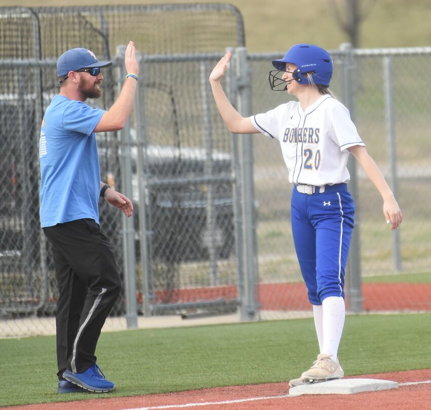 Mountain Home's Natalie Fleet gets a high-five from coach Blake Hendricks after hitting an RBI triple in the Lady Bombers' 7-6 victory over Southside on Monday.