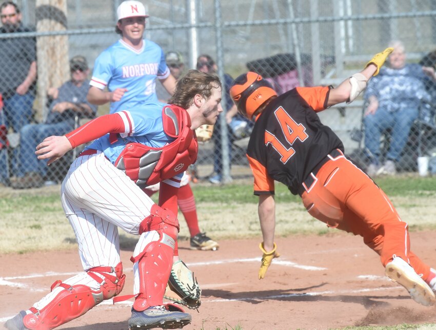 Viola's Braden Williams (14) attempts to avoid the tag of Norfork catcher Caden Hatfield on Wednesday at Viola City Park.
