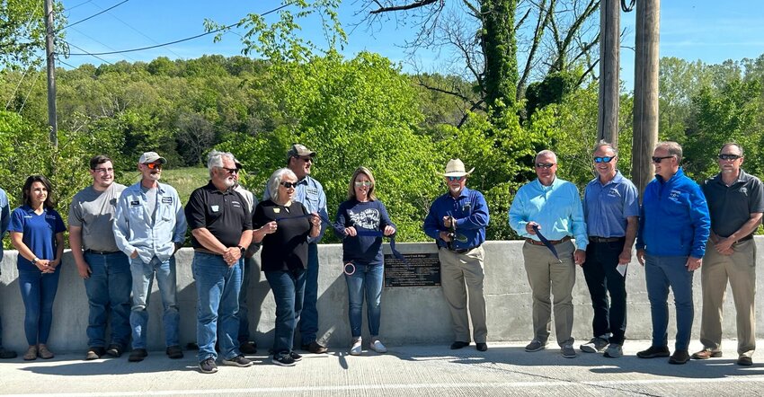 Local dignitaries, current and former elected officials and Baxter County workers are shown during the dedication of the Denton Ferry Bridge on Tuesday morning. The new structure replaces a low-water bridge that served the area for almost 40 years.   Caroline Spears/The Baxter Bulletin