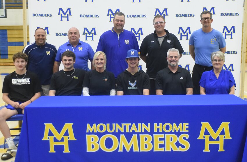 Mountain Home outfielder Jett Hannaford (seated, fourth from left), pictured with family and coaches, signed Monday a letter of intent to play college baseball at Arkansas State University-Mountain Home.