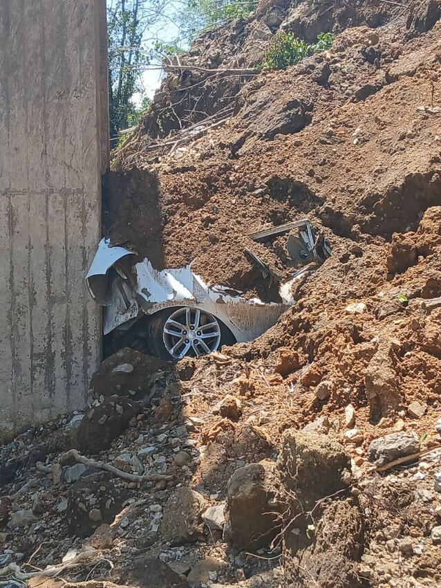 Anthony Lucas' vehicle remains embedded in the mud under the Moccasin Creek Bridge in rural Marion County. During Wednesday's storm, the bridge separated into two sections. Unable to see in the pelting rain, Lucas attempted to drive across the bridge and plummeted into the raging water below.&nbsp;   Submitted Photo