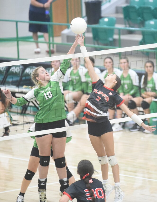 Flippin's Haylen Wolf (2) and Yellville-Summit's True Layton (10) battle for a ball above the net Tuesday night.