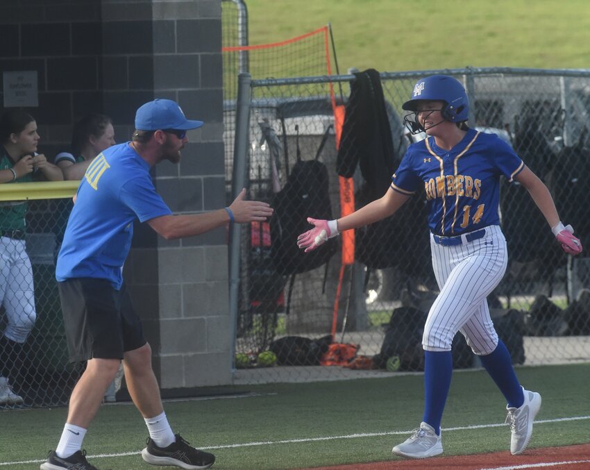 Mountain Home coach Blake Hendricks congratulates Laken Anderson after a home run during a recent home game.