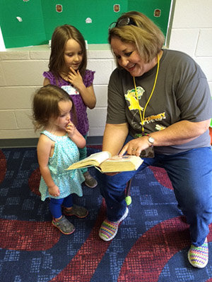 GBC state missionary Jenni Carter reads to Kayla and Erin Riddle during Vacation Bible School at Kennesaw First Baptist Church. 