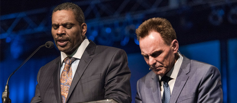 K. Marshall Williams, left, senior pastor of Nazarene Baptist Church in Philadelphia, prays next to Ronnie Floyd, president of the Southern Baptist Convention, during the June 16 evening prayer session of the SBC annual meeting at the Greater Columbus Convention Center. “It’s time for us to be the people of God” and to love one another regardless of race or ethnicity, he prayed. PAUL W. LEE/BP