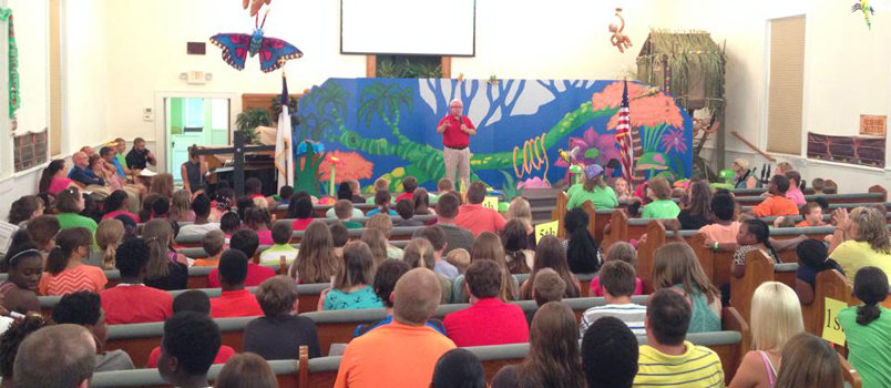Grace Baptist, Monroe pastor Tommy Fountain addresses the record crowd of children attending VBS at the church this summer. Attendance registered at 359 for the event. GRACE/Special