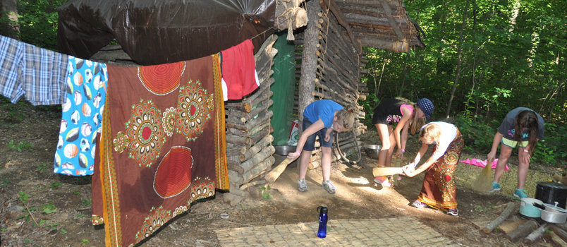 Campers perform a variety of chores similar to what their counterparts in a Mozambique village would encounter, such as sweeping the ground inside and outside a village hut, in a missions recreation experience at Camp Pinnacle. JOE WESTBURY/Index