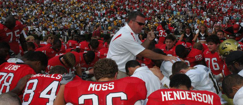 UGA football chaplain Kevin "Chappy" Hynes prays with the team following a game against the University of Colorado. Photo courtesy 