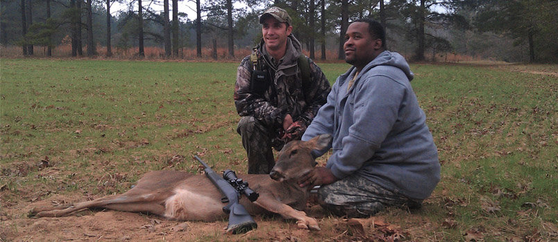 Military servicemen Reuben Pedro, left, and Damion Peyton, right, pose on a Wounded Warriors hunt in 2012. The deer was Peyton's first to kill. 