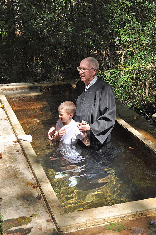 The ceremony begins with a brief description of the meaning of baptism ... placing young Alan Peeler under the water symbolizing his death to self ... and arising to a new life through faith in Jesus Christ. JOE WESTBURY/Index