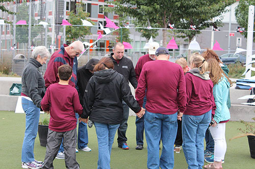 Members of a mission team from Poplar Springs Baptist Church in Hiram are led by Pastor Wayne Meadows, center in black shirt, praying together before New City Church's annual community carnival last fall. NEW CITY/Special