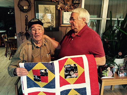 Clyde Harkins, left, and associational missionary Doug Merck hold the Quilt of Valor presented to Harkins at Zion Baptist Church in December. Harkins has been a deacon at Zion for years. GERALD HARRIS/Index