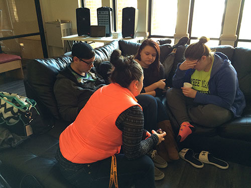 BPC Dean of Women Rebekah Meahl, orange vest, prays with students in the student center. LAUREN YOUMANS/Special