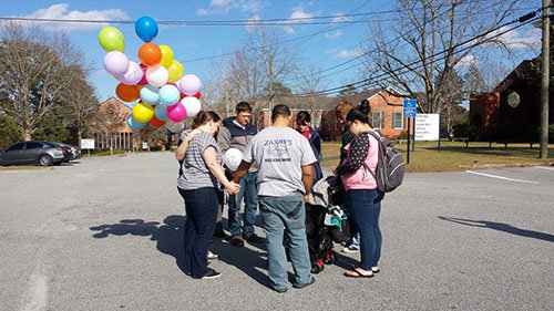 A group of students from the Brewton-Parker College BCM pray before releasing 40 balloons with prayers written on them. The symbolism, says campus minister Lauren Youmans, was of prayers going to God. LAUREN YOUMANS/Special