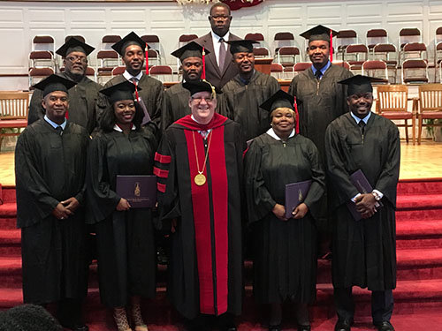 Students attaining leadership certificates and degrees through the New Orleans Seminary North Georgia Hub recently took part with classmates in the school's commencement May 13. Standing left to right, back row are Willie Sherman Curtis, Rony Obed Beague, Yves Ciano Menager, Jean-Baptiste Eddy, and Jean F. Daniel. Front row, left to right, are Johnny Gaston, Stephanie Joy Pigg, who earned her Bachelor of Arts degree, NOBTS President Chuck Kelley, Ella Louise Parks, and Alexandre John Muller Dorcelly. Standing in rear is Seneque Saintil, director of the Atlanta-area Haitian Center.