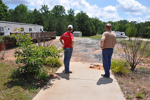 Holly Hayes and Stan Patterson stand at what used to be the front door of the growing congregation which was quickly reduced to burned ashes. The building, a double-wide mobile chapel, had been donated to the new church start by the Georgia Baptist Convention (now Georgia Baptist Mission Board). JOE WESTBURY/Index