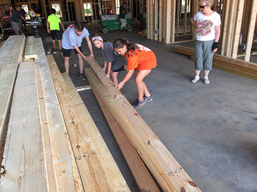 Dylan Collins of Church 213, left, and Leala Hutchens and Carlyn Wells of First Cochran, center and right, move boards as part of the younger volunteers. JOE WESTBURY/Index