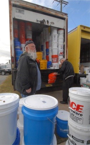 Ronald Clements. foreground, and Lloyd Britt, background, both from First Church Centerville, collect and check the "Buckets of Care" donated at the Georgia Baptist annual meeting. SHERRI BROWN/Index