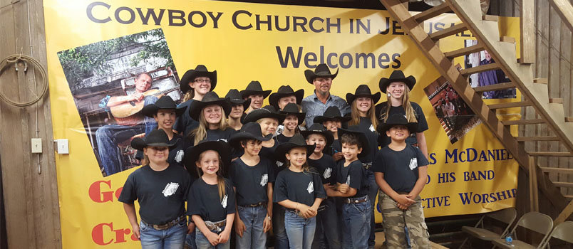 John Riggs, in back stands with the Cowboy Kids of Double HH Ranch in Jerusalem. Rebecca Hampton, who owns the ranch, can be seen to the left of Riggs. DOUBLE HH Ranch/Special