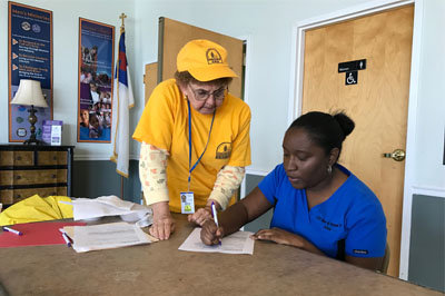 Hurricane Matthew survivor Latrees Reeves applies for disaster relief assistance from one of Georgia Baptist's chainsaw crews at the Savannah Baptist Center. Explaining the process is volunteer Gerry Rowland, left, of Bloomingdale. JOE WESTBURY/Index