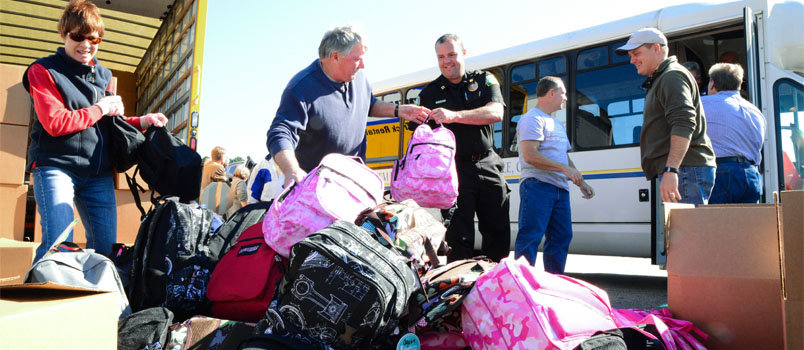 Volunteers collect backpacks being delivered to the 2013 annual meeting held at First Baptist Church Church of Woodstock. KELLY DURHAM/Index